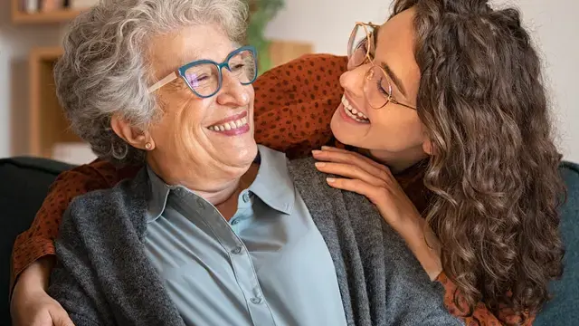 Những người phụ nữ lớn tuổi và trẻ tuổi đang mỉm cười.​​ 