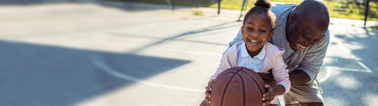 Father and daughter playing basketball